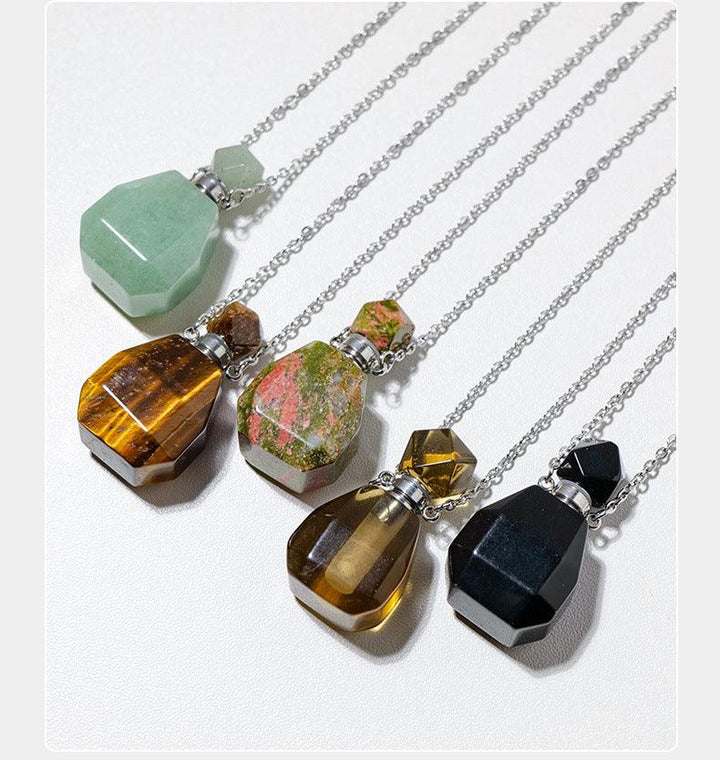 crystal perfume bottle raw stone necklace pendant on the table