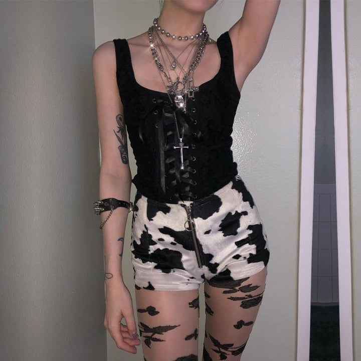 a woman wear a gothic punk strappy black sleeveless top vest