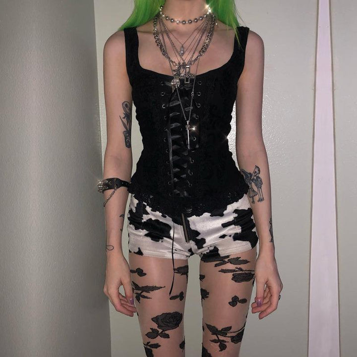a woman wear a gothic punk strappy black sleeveless top vest