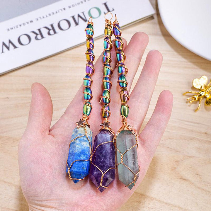 hexagonal crystal magic energy wand with gold wire wrapping on the hand