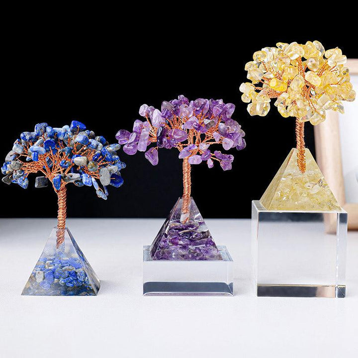 three natural crystal bonsai tree with resin pyramid base on the table