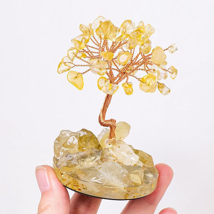 natural crystal gemstone tree with resin base on the hand