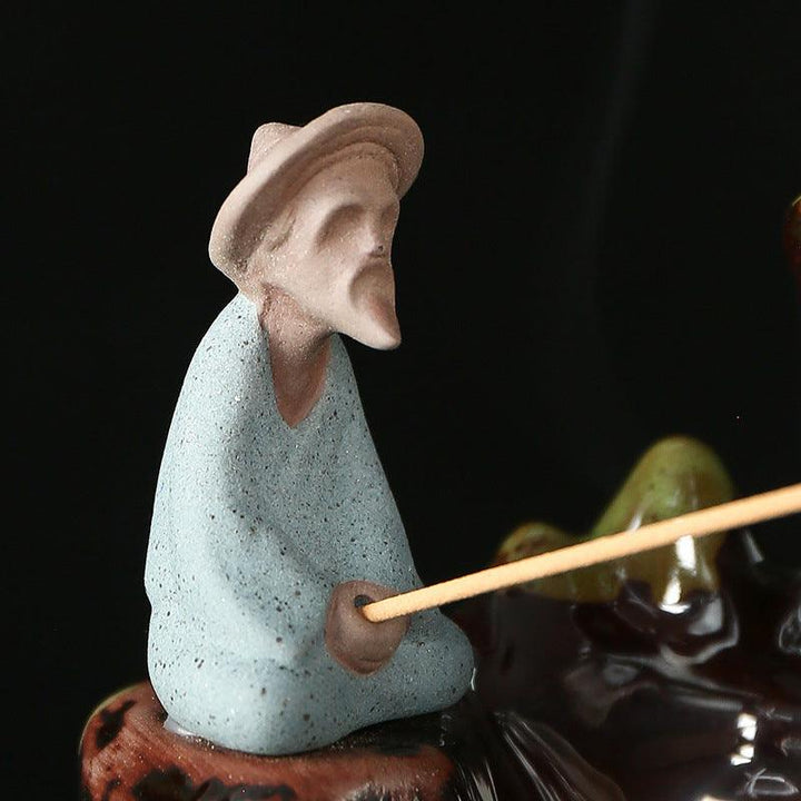 details of old man fishing water backflow incense burner holder on the table